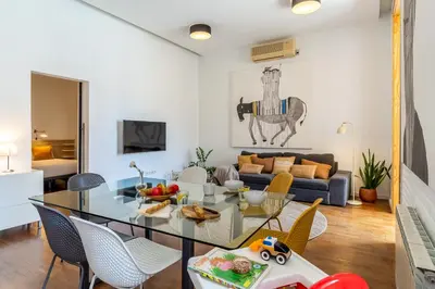 a living room with a glass table and chairs at Canela Homes BARCELONA ART in Barcelona