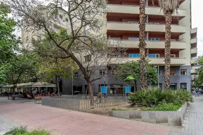 a building with a fence and trees in front of it at Canela Homes BARCELONA ART in Barcelona