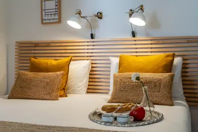 a tray of food on a bed with yellow pillows at Canela Homes BARCELONA ART in Barcelona