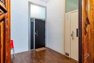 a hallway with two doors and a red chair at Canela Homes BARCELONA ART in Barcelona