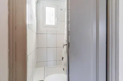 a white bathroom with a shower and a toilet at Canela Homes BARCELONA BAILÉN in Barcelona