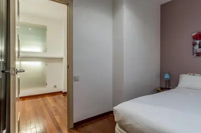a bedroom with a white bed and a mirror at Canela Homes BARCELONA ARAGÓ in Barcelona