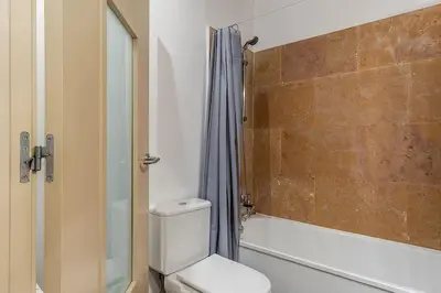 a bathroom with a toilet and a tub and a shower at Canela Homes BARCELONA ARAGÓ in Barcelona