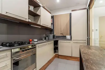 a kitchen with white cabinets and a stove top oven at Canela Homes BARCELONA ARAGÓ in Barcelona