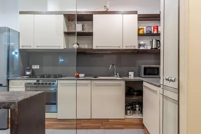 a kitchen with white cabinets and a sink and a stove at Canela Homes BARCELONA ARAGÓ in Barcelona