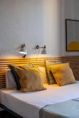 a bed with yellow pillows and two lights on it at Canela Homes BARCELONA VLC306 in Barcelona