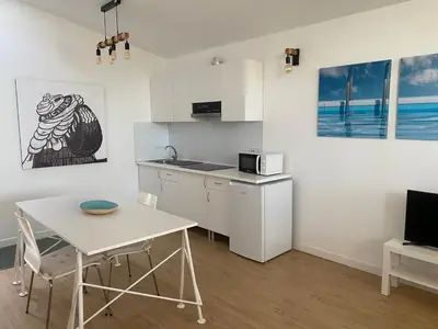 a kitchen with a table and a small table and a table and chairs at LOFT CAL XURIGUER in Font-Rubí