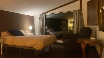 a bedroom with a bed and a couch and a chair at LOFT CAL XURIGUER in Font-Rubí