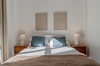 a bedroom with a large bed with blue pillows at Canela Homes BARCELONA NINOT in Barcelona