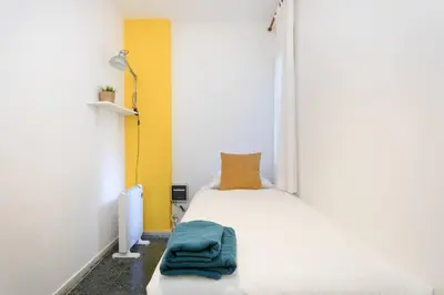 a bedroom with a white bed with a blue towel on it at Canela Homes BARCELONA PARK GÜELL in Barcelona