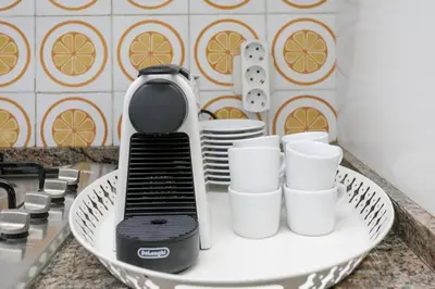 a blender on a plate on a counter with cups at Canela Homes BARCELONA PARK GÜELL in Barcelona