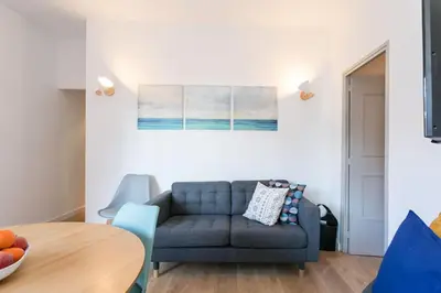 a living room with a blue couch and a table at Canela Homes BARCELONA COZY in Barcelona