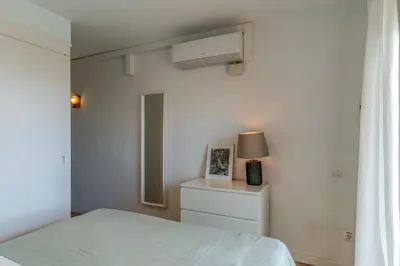 a bedroom with a bed and a lamp and a window at Canela Homes COSTA CASTELLDEFELS in Castelldefels