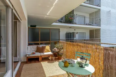 a patio with a table and a couch on a balcony at Canela Homes COSTA CASTELLDEFELS in Castelldefels