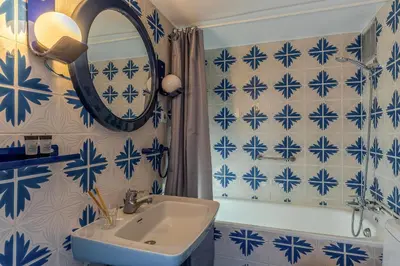 a blue and white bathroom with a sink and a mirror at Canela Homes COSTA CASTELLDEFELS in Castelldefels