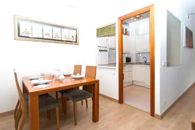 a dining room with a table and a kitchen at Apartment Bright Sagrada Familia in Barcelona