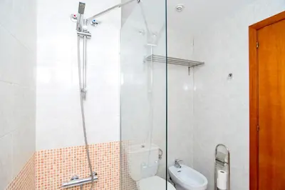 a bathroom with a shower with a toilet and a sink at Apartment Bright Sagrada Familia in Barcelona