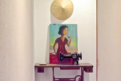 a painting of a woman on a table with a sewing machine at Auditori Barcelona in Barcelona