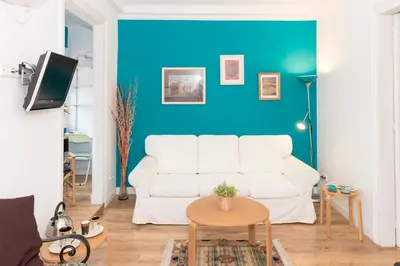 a living room with a white couch and a blue wall at Fira Suites in Barcelona