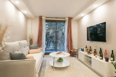 a living room with a couch and a tv at YOUR HOME - Camp Nou Apartment in Hospitalet de Llobregat