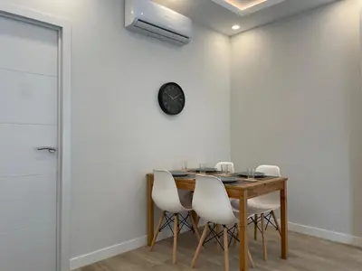 a dining room with a wooden table and white chairs at manresa universidad in Manresa