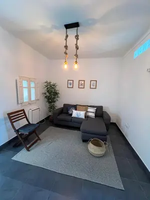 a living room with a couch and a chair at Apartments near Ramblas - Only for stays over 32 days in Barcelona