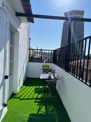 a balcony with a table and a view of a city at Apartments near Ramblas - Only for stays over 32 days in Barcelona