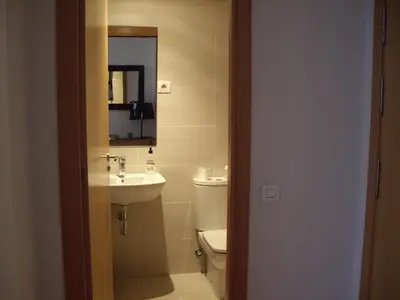 a bathroom with a sink and a toilet and a mirror at Fira Duplex in Hospitalet de Llobregat