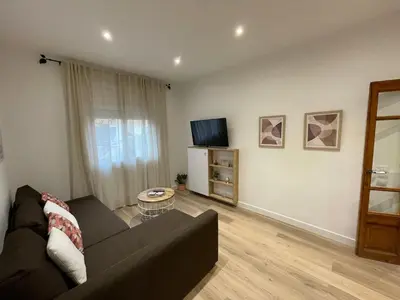 a living room with a couch and a tv at Nice Apartment 2 Bedrooms Well Connected in Cornellà de Llobregat