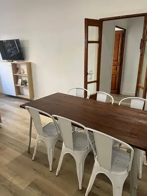 a wooden table with white chairs around it at Nice Apartment 2 Bedrooms Well Connected in Cornellà de Llobregat