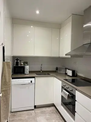 a kitchen with white cabinets and a sink at Nice Apartment 2 Bedrooms Well Connected in Cornellà de Llobregat