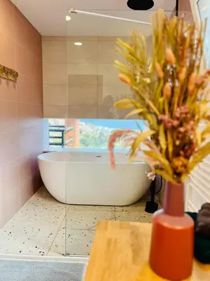 a bathroom with a white tub and a vase with flowers at Villa Nova Vida Barcelona in Teià