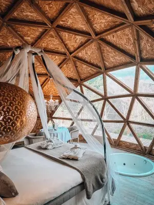 a bed in a room with a large window at Bubble Suites in Canyelles