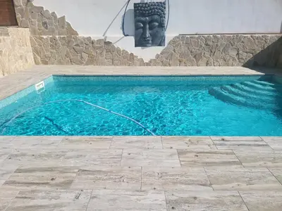 a swimming pool with a statue in front of a building at Villa Urbina in Olerdola