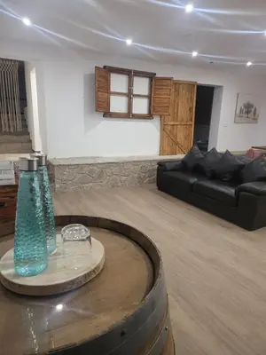 a living room with a black couch and a table at Villa Urbina in Olerdola