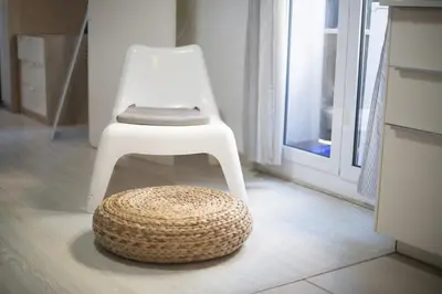 a white chair and a stool in a room at Catalunya Casas Lovely apartment central Barcelona 100m to beach! in Barcelona