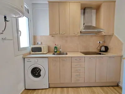 a kitchen with a washing machine and a microwave at Cozy apartment in Gracia in Barcelona