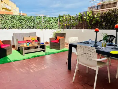a patio with a table and chairs and a couch at Calm Terrace Barcelona in Barcelona
