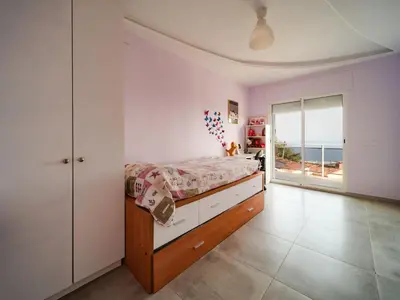 a bedroom with a bed and a view of the ocean at Villa Elena in Pineda de Mar