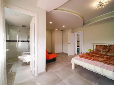 a bedroom with a large bed and a bathroom at Villa Elena in Pineda de Mar