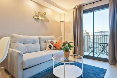 a living room with a couch and a glass table at bonito piso cerca del campo de futbol de barcelona in Hospitalet de Llobregat