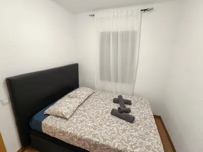 a teddy bear laying on a bed in a bedroom at Family apartment Besos 2 in Sant Adria de Besos