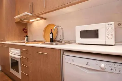 a kitchen with a sink and a microwave at Port I Espectacular apartament con terraza in Barcelona
