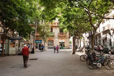 a street with people walking down a street with trees at Port I Espectacular apartament con terraza in Barcelona