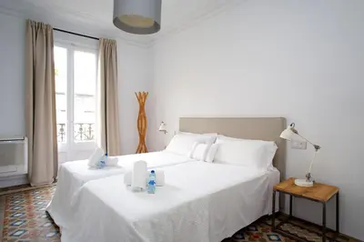 a bedroom with a large white bed with towels on it at BarcelonaForRent The Claris Suites I in Barcelona