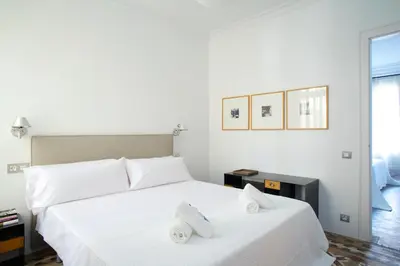 a bedroom with a large white bed with towels on it at BarcelonaForRent The Claris Suites I in Barcelona