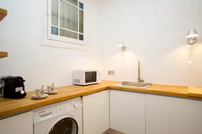a kitchen with a washer and a microwave on a counter at BarcelonaForRent The Claris Suites I in Barcelona