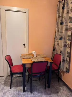 a table with four chairs and a door with a door at Bonita Habitación en chalet in Barcelona
