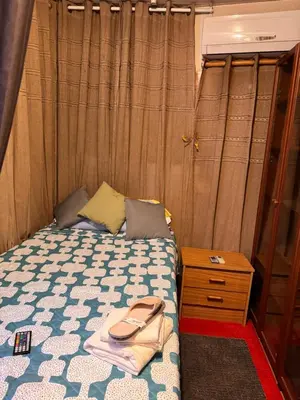 a small bedroom with a bed and a wooden cabinet at Bonita Habitación en chalet in Barcelona
