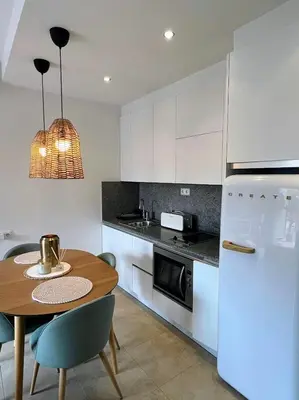 a kitchen with a table and a white refrigerator at Loft acogedor cerca de Barcelona in Terrassa